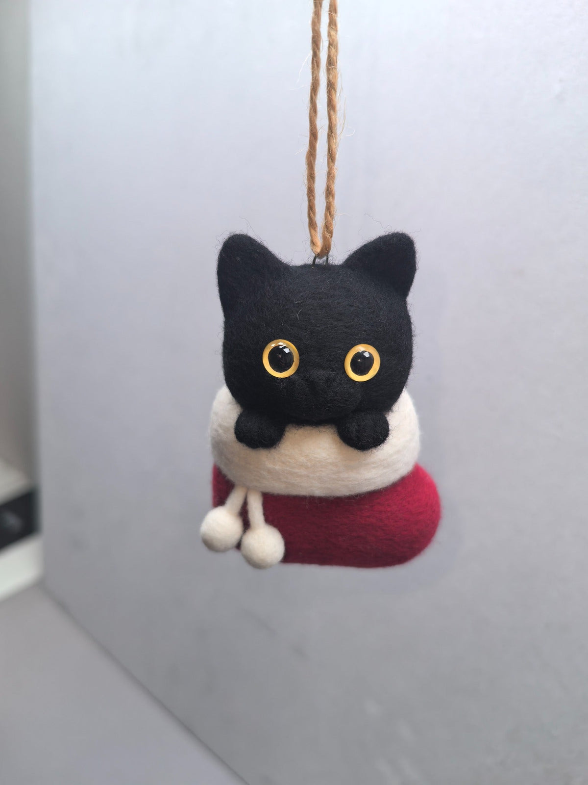 Handmade needle-felted black cat nestled in a red Christmas stocking ornament, crafted by ilovefelt