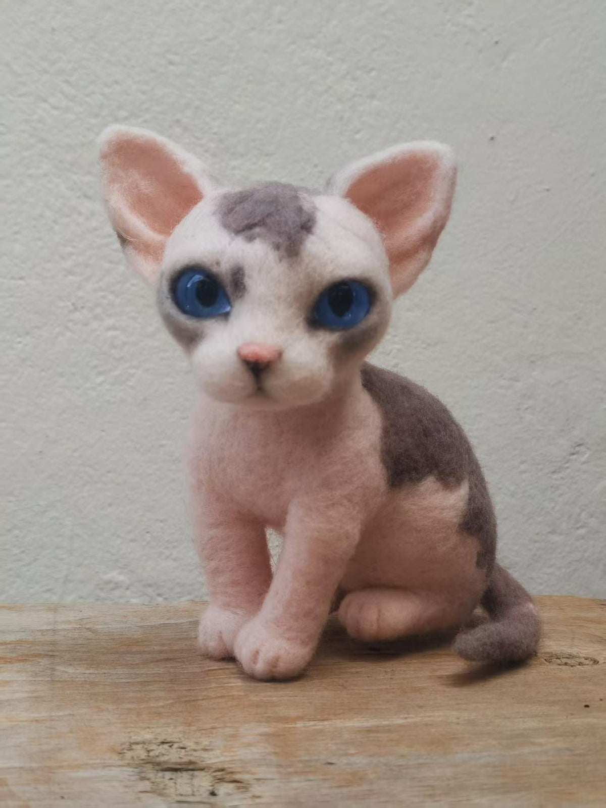 Handmade needle-felted Sphynx cat sculpture with large blue eyes