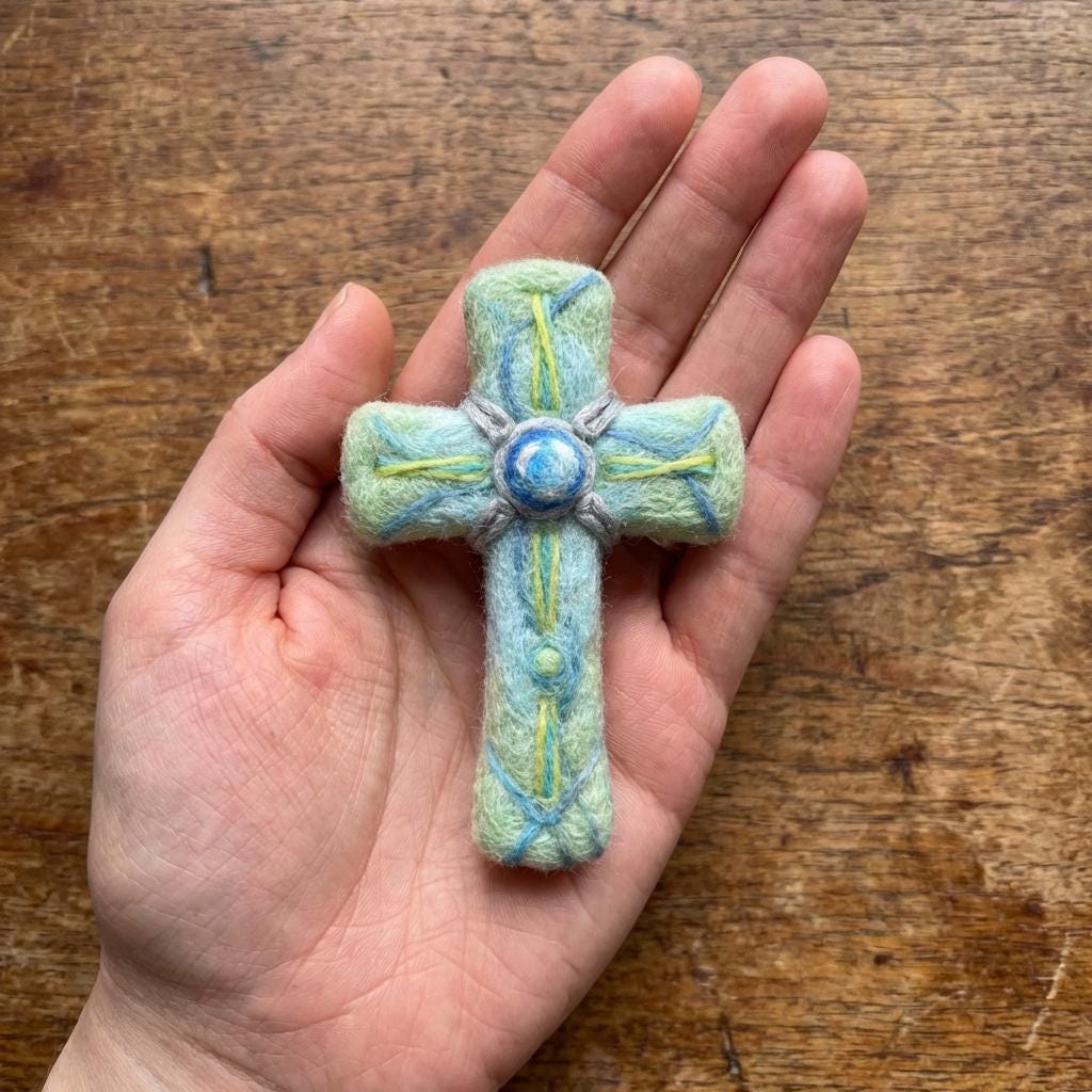 Hand felted wool floral cross pendant from Jiajia Felt Studio, featuring colorful felted wool flowers on a cross-shaped jewelry piece.