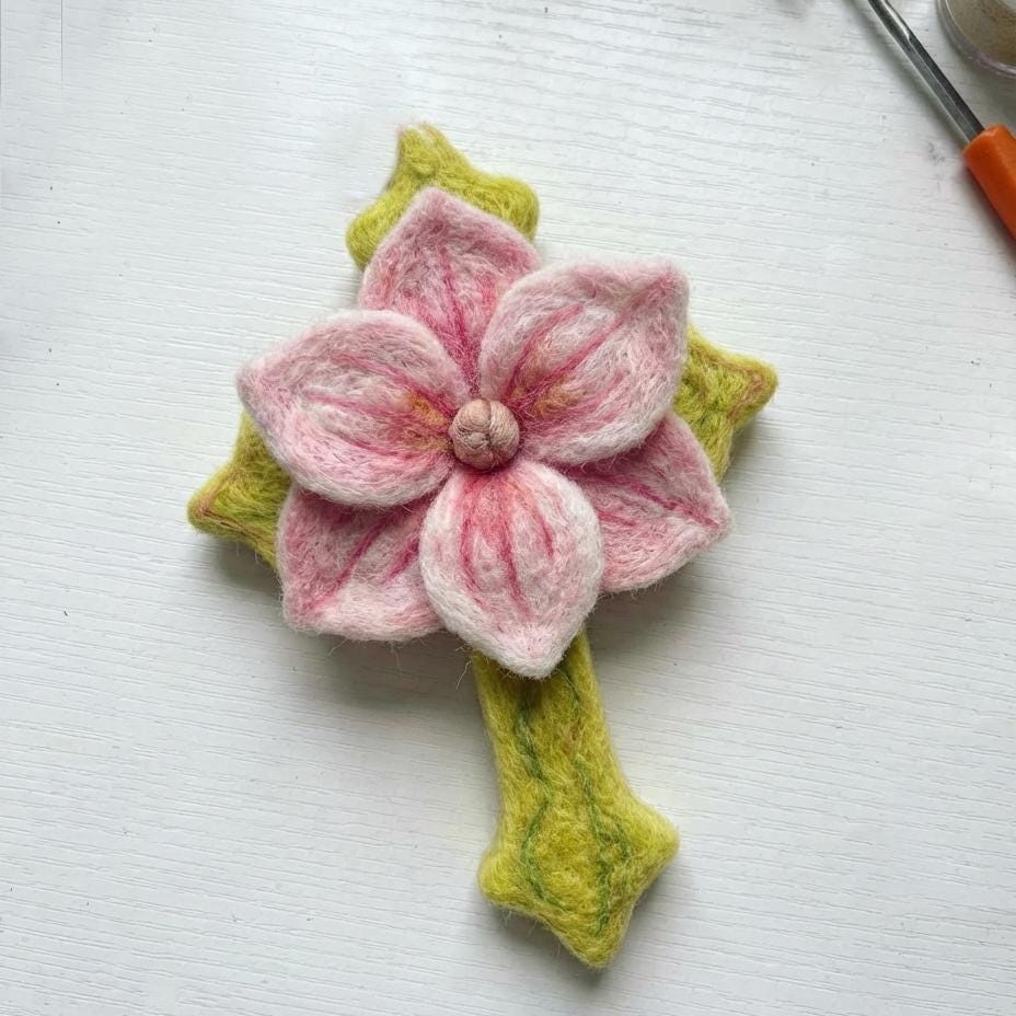 Hand felted wool floral cross pendant from Jiajia Felt Studio, featuring colorful wool flowers on a felt jewelry cross.