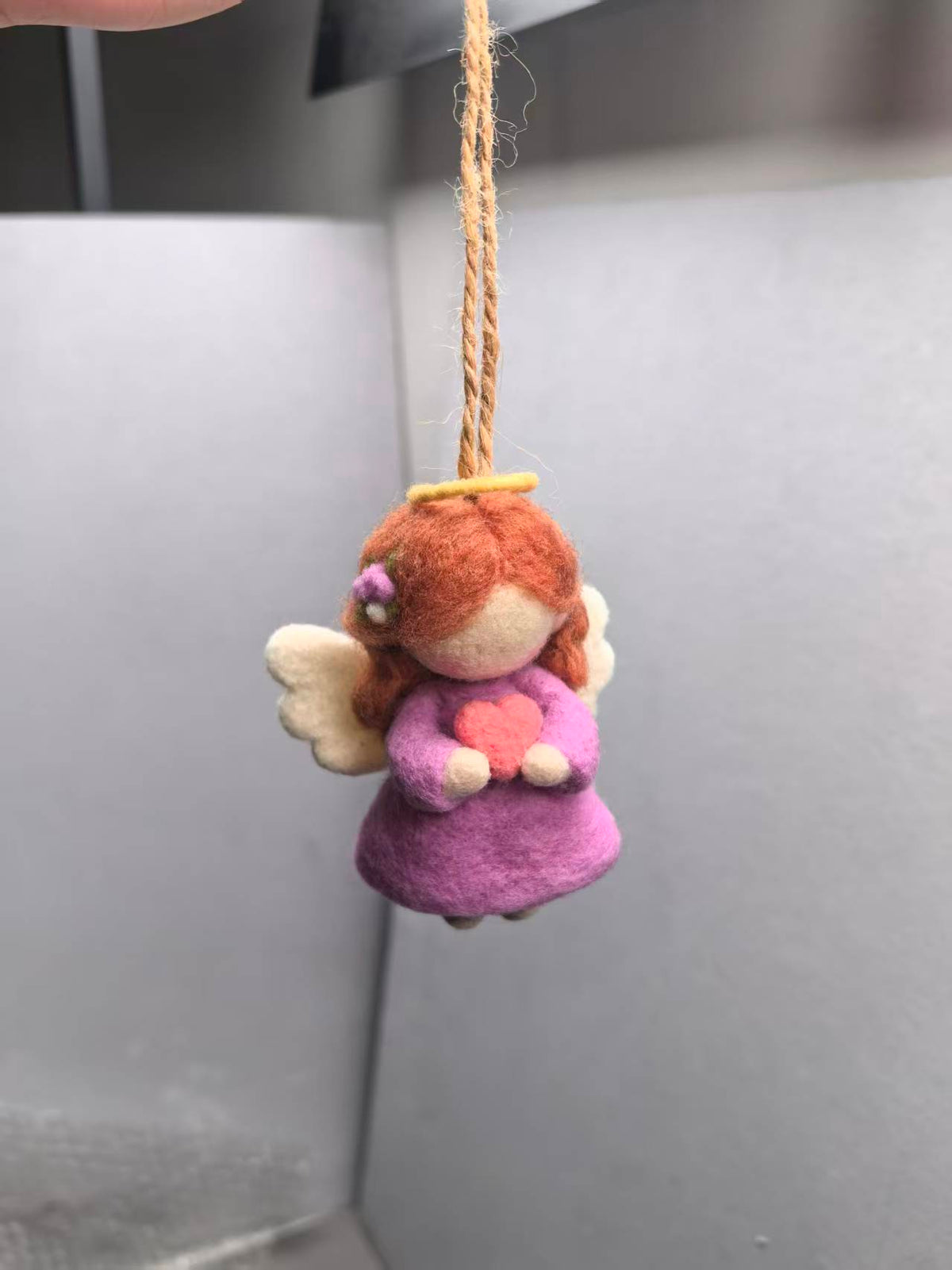 Needle felted angel ornament with red curls, halo, wings and a heart, on a jute loop