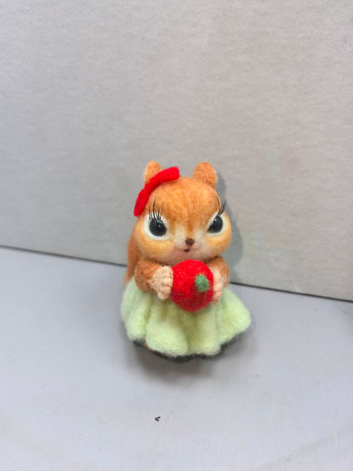 Real studio photo: needle felted squirrel with red bow and green skirt holding an apple (Style B)