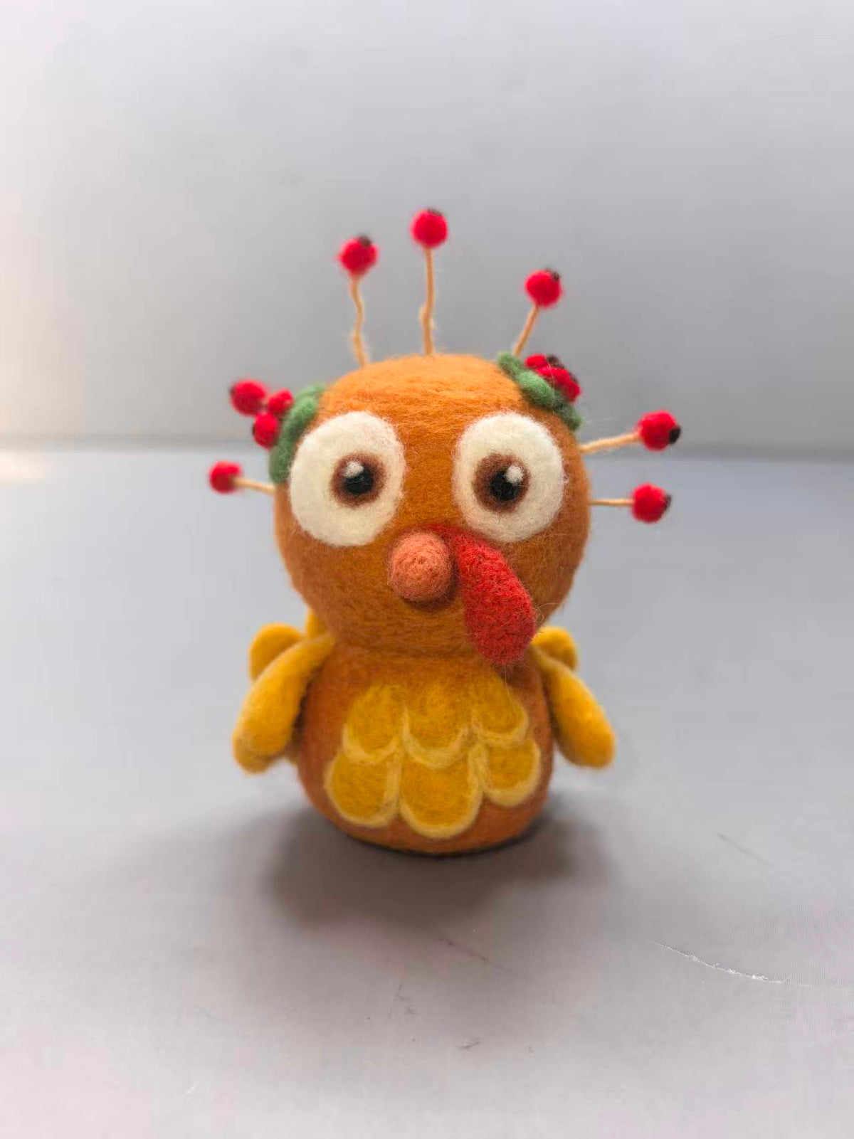 Needle felted turkey with big eyes and berry-tipped feathers