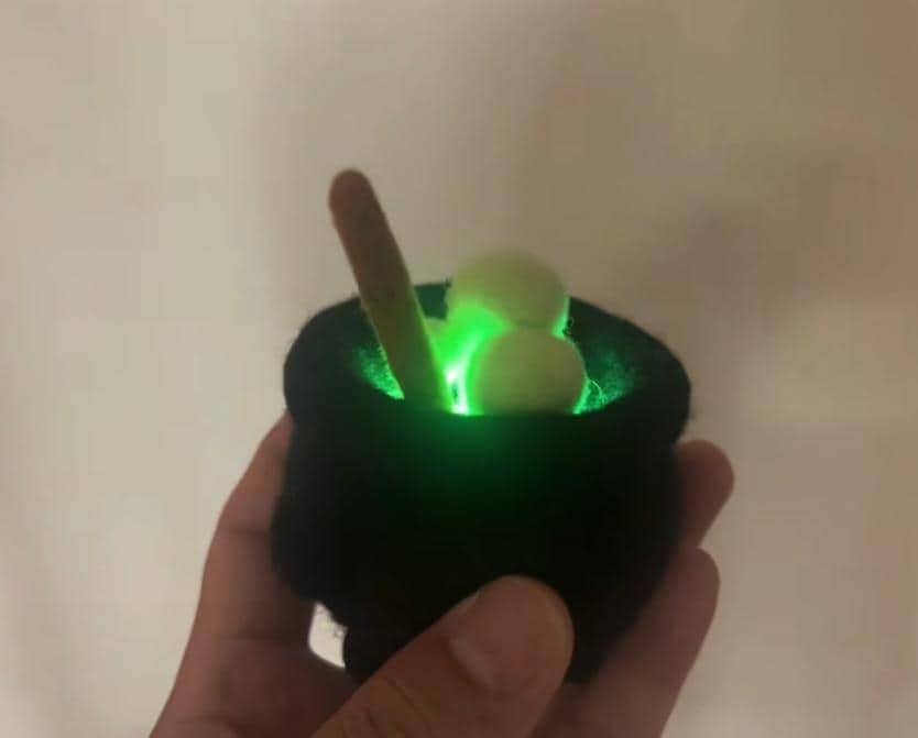 Light-up needle felted cauldron with green internal glow, alternate view