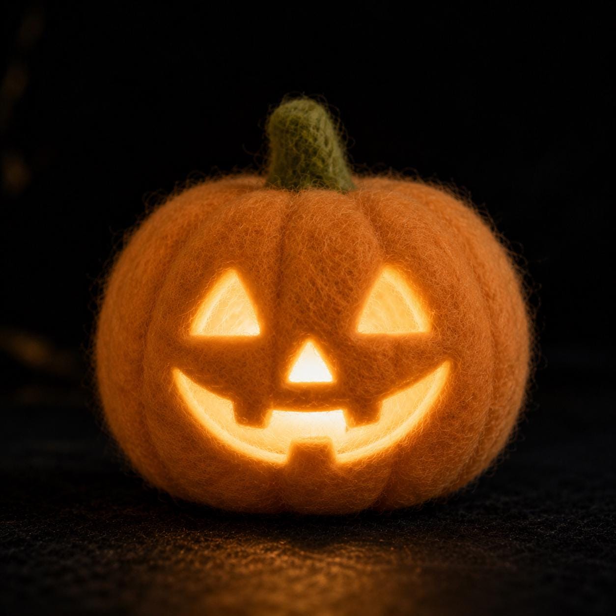 Light-up needle felted jack-o'-lantern pumpkin with glowing carved face