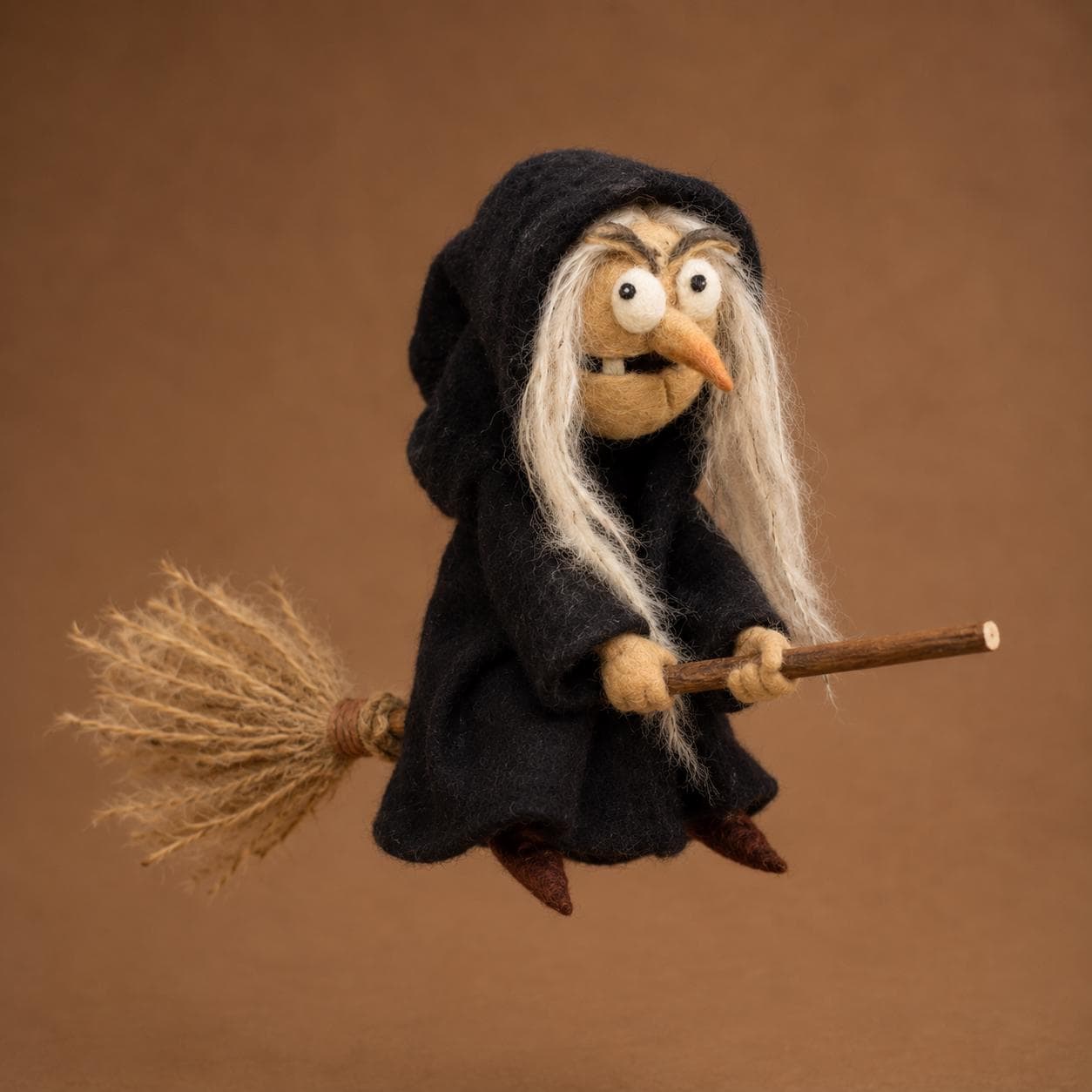 Needle felted witch figurine riding a wooden broomstick